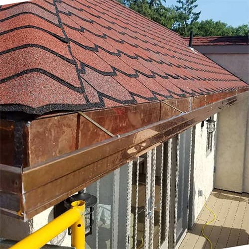 Photo of copper gutters on a red roofed home