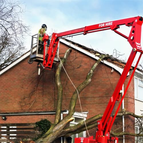 Photo of a house undergoing repairs with a worker at the roof via a cherrypicker